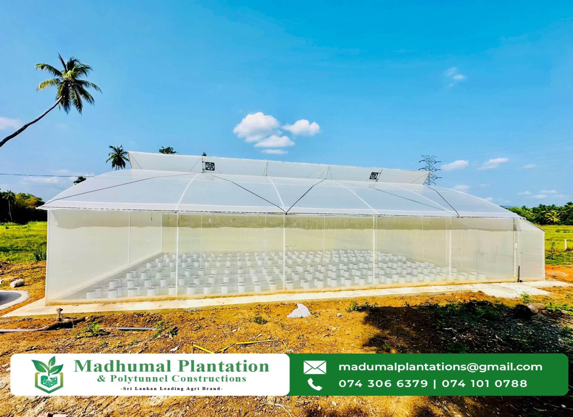Completed greenhouse structure with ventilation fans on a clear day